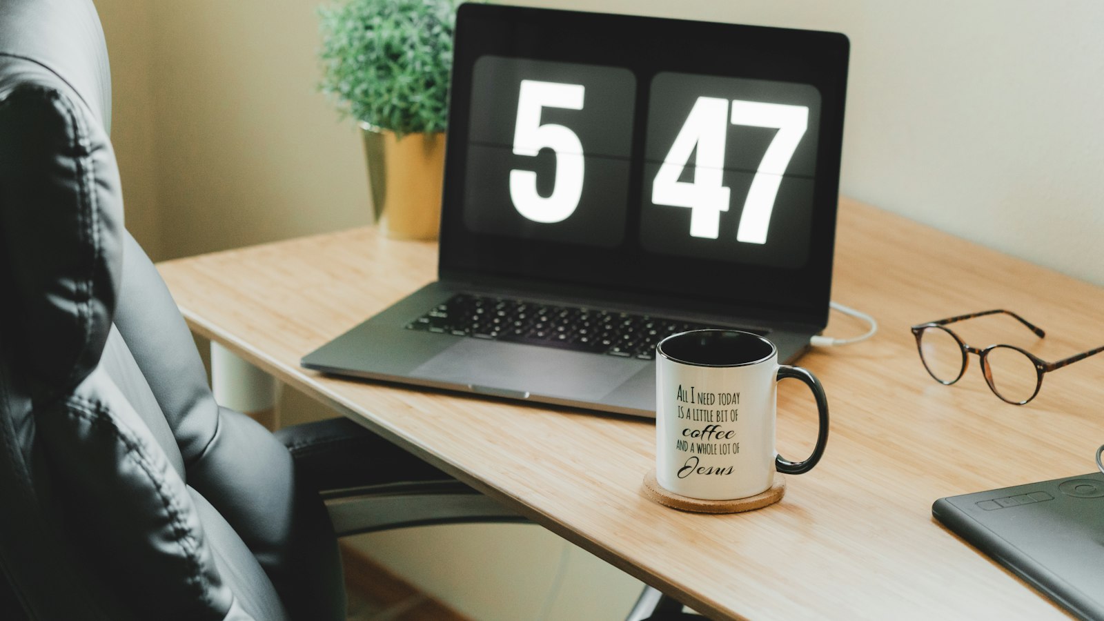 Turned-on MacBook Pro beside white and black ceramic mug